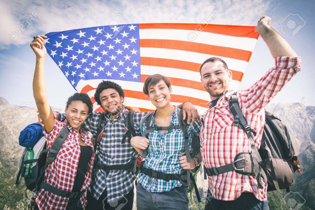 people with usa flag on top of mountain
